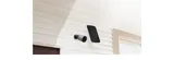 KAAMERAMAAILM.EE - An EZVIZ BC1C 2MP (sama nagu BC1, aga töötab otse Wifi pealt) kaamera ja ristkülikukujuline päikesepaneel on paigaldatud valge puidust hoone välisseinale akna ja ukse lähedale, pakk (4/5)